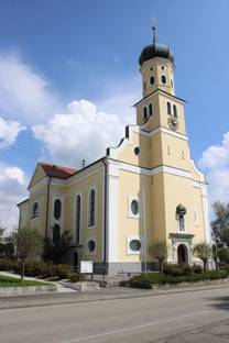 Außenansicht der gelb-weißen Kirche Mater Dolorosa von Engelswies vor blauem Himmel.