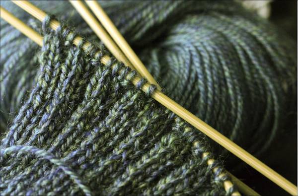Quelle: Elizabeth Keckert, Elizabeth Keckert graues Wollknäul mit angefangener Strickarbeit